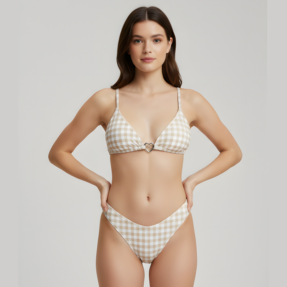 Woman wearing a checkered bikini with a heart design on a plain background